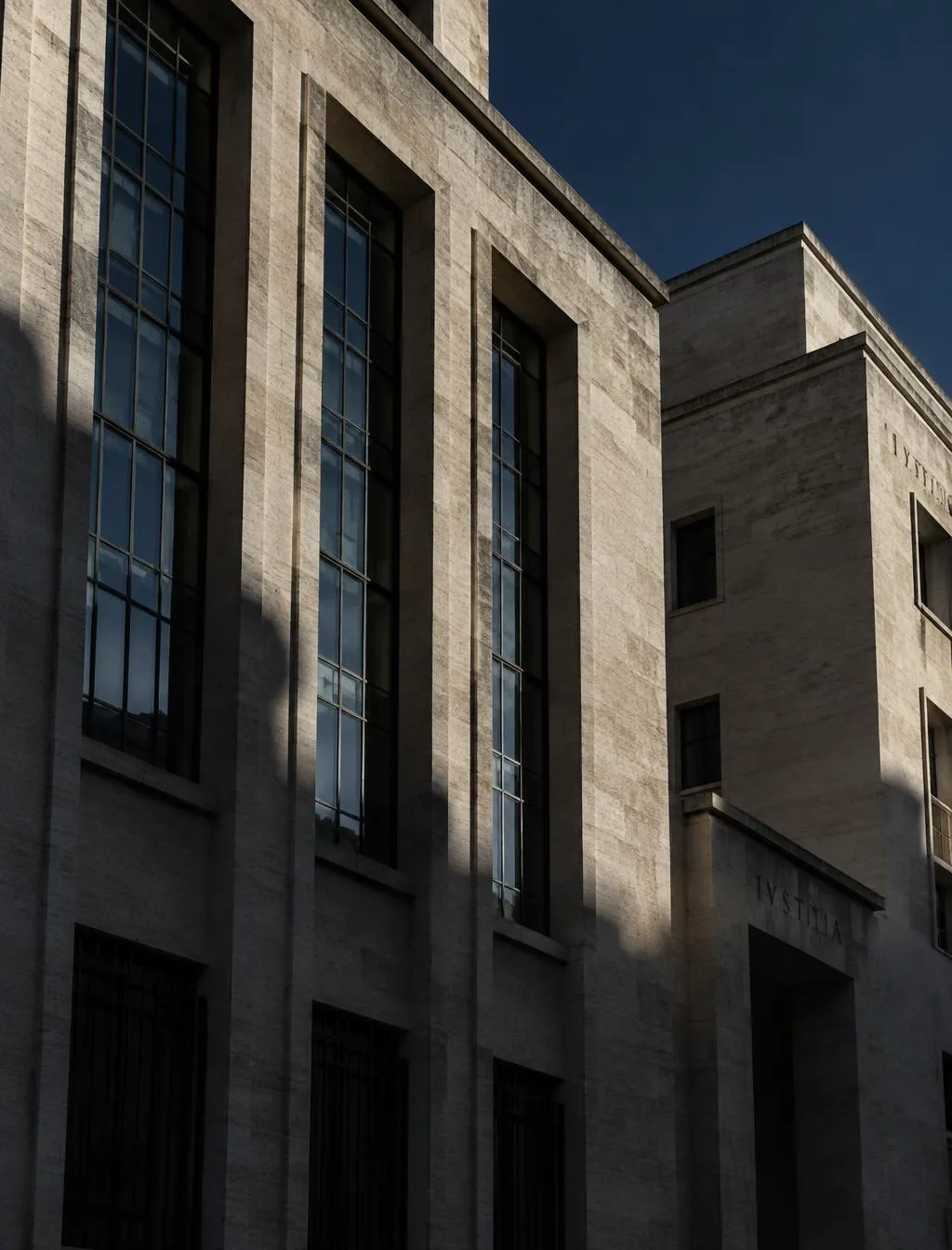 Facciata in travertino di un edificio razionalista milanese in luce radente